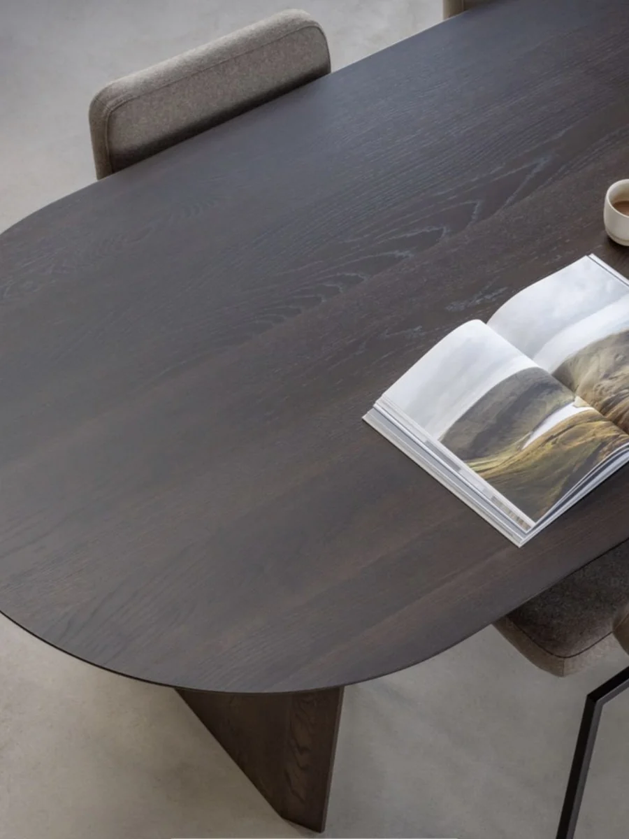 CGI close-up of a dark oak dining table with an open magazine