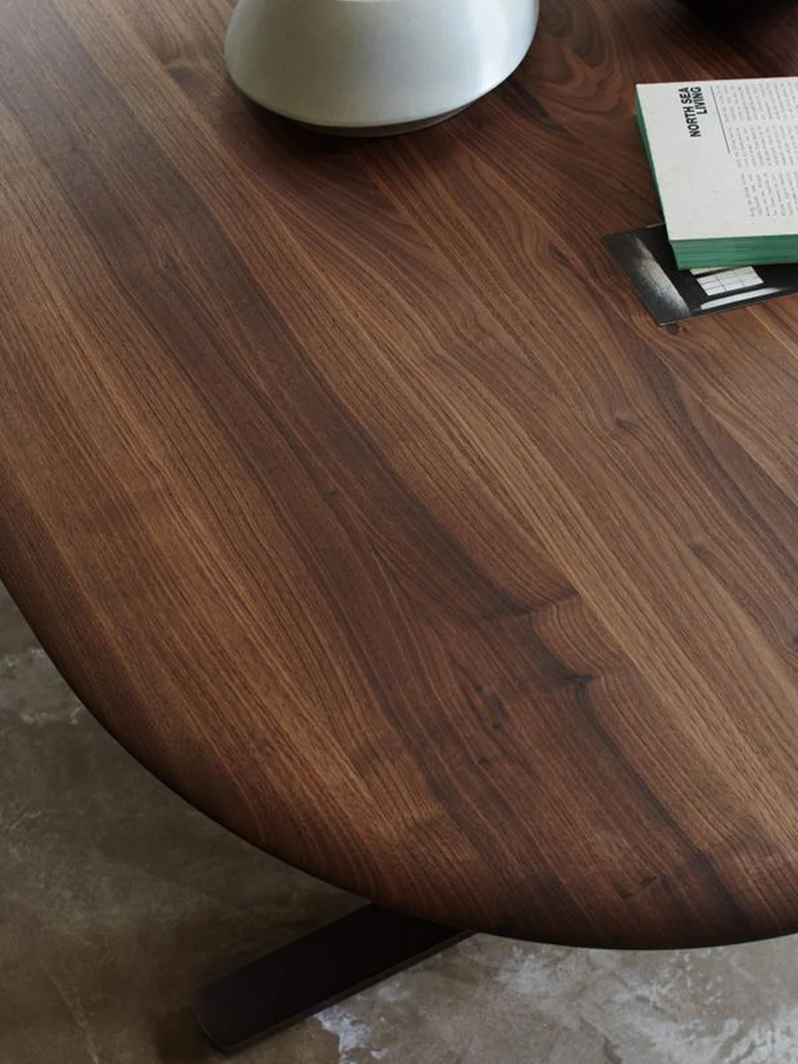 CGI close-up of a walnut oval dining table top and its sculpted base