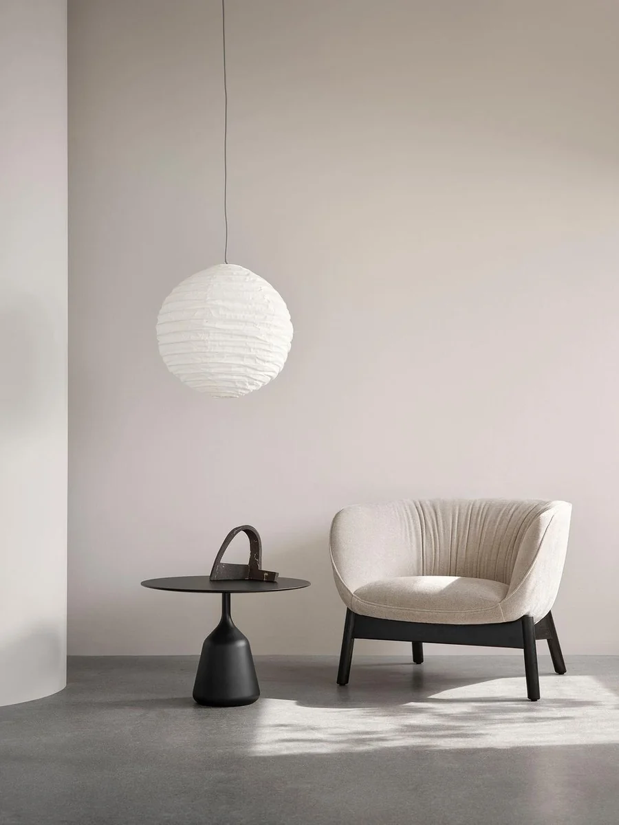 CGI lifestyle render of a cream ribbed armchair under a paper pendant lamp
