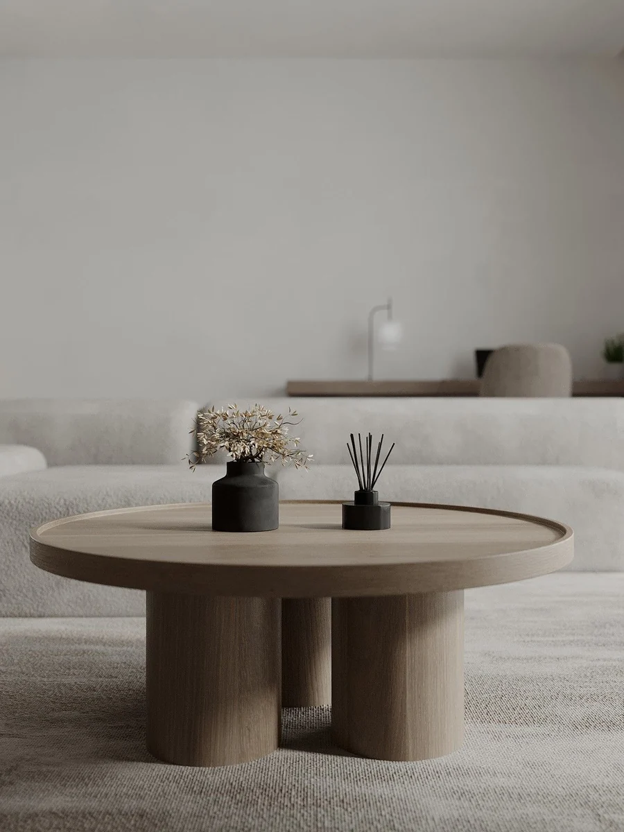 CGI lifestyle render of a travertine round coffee table styled with ceramics