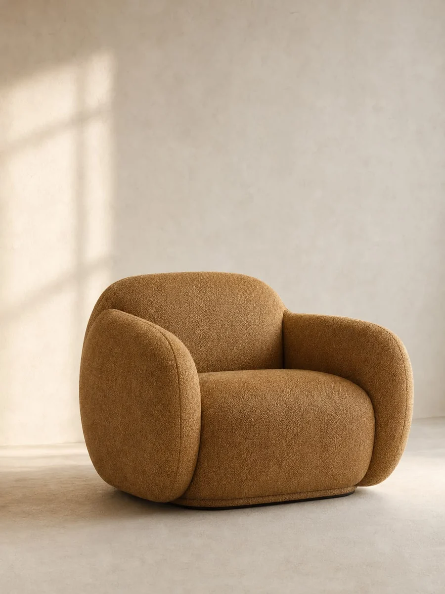 CGI packshot of a caramel boucle armchair on a warm neutral ground