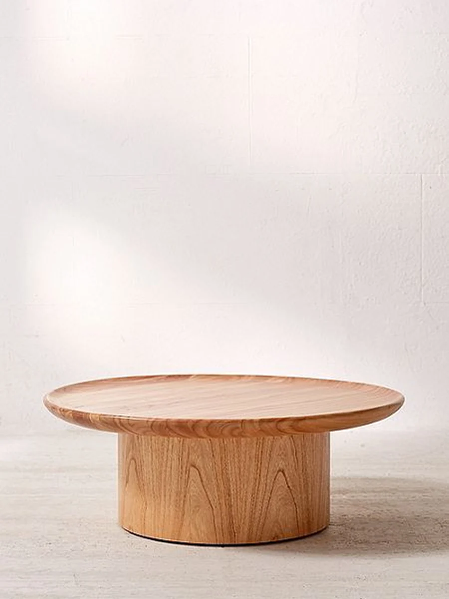 CGI packshot of a round oak coffee table on a plaster wall backdrop