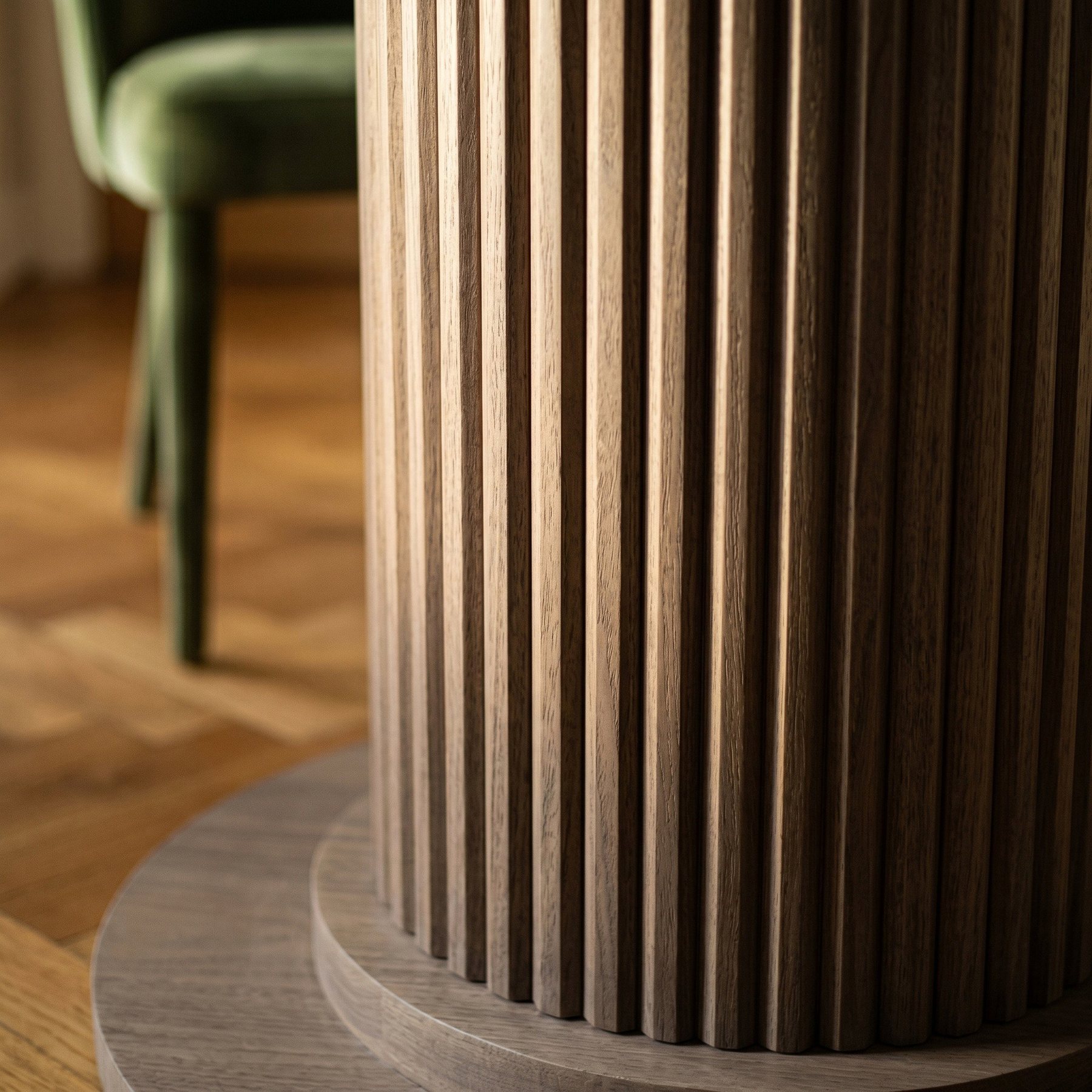 AI lifestyle scene, close detail of the fluted timber pedestal, a green velvet chair behind